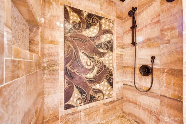 The main floor shower finished in natural Honey Onyx stone and features an imported natural stone mosaic.