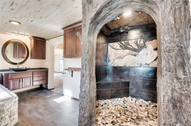 The shower in the primary suite features this hand sculpted concrete “tree shower” which was created in place from Master Mason, Bruce Aalmo.