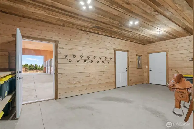 Tack room off shop with shelving, bridle and saddle racks.
