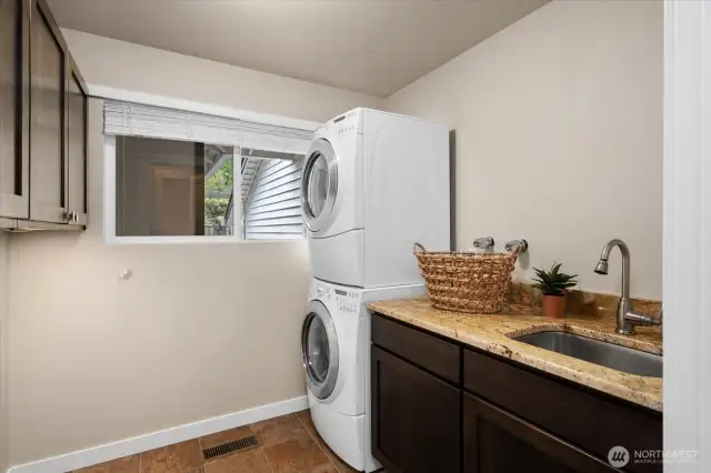 Spacious utility room with utility sink and cabinetry.