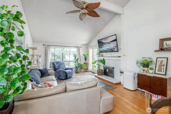 Large living room with soaring ceilings, a wood burning fireplace, and plenty of space to entertain.