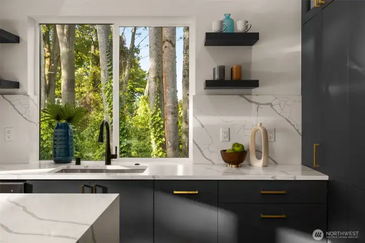 A glimpse into the home’s artistry—sleek open shelving, matte finishes, and subtle contrasts come together to create a kitchen that is both bold and beautifully balanced.