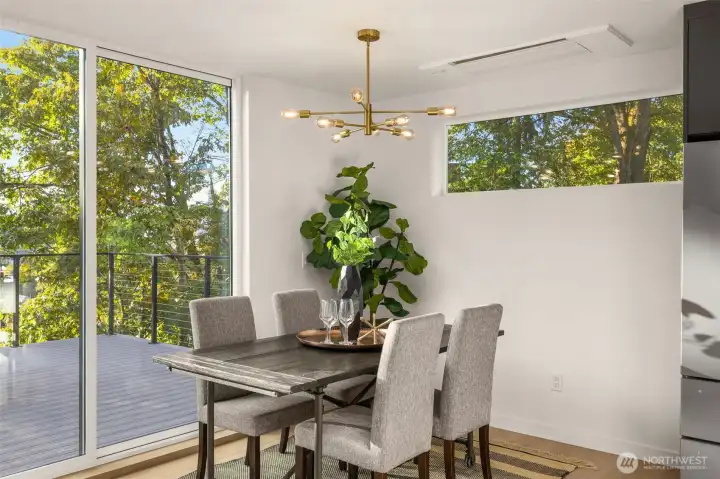 The dining area feels like a treehouse sanctuary—surrounded by windows and greenery, it’s the perfect spot to enjoy quiet breakfasts or lively dinner gatherings under the soft glow of pendant lighting.