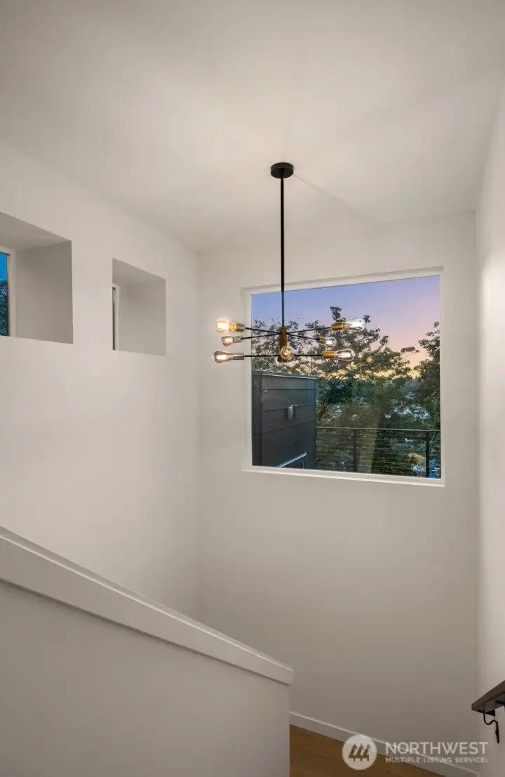 Transitional spaces in this home are anything but ordinary—architectural hallways accented by modern sconces and large picture windows create gallery-like moments between rooms.