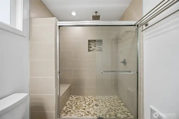 Primary walk in shower with fountain shower head. and seat.