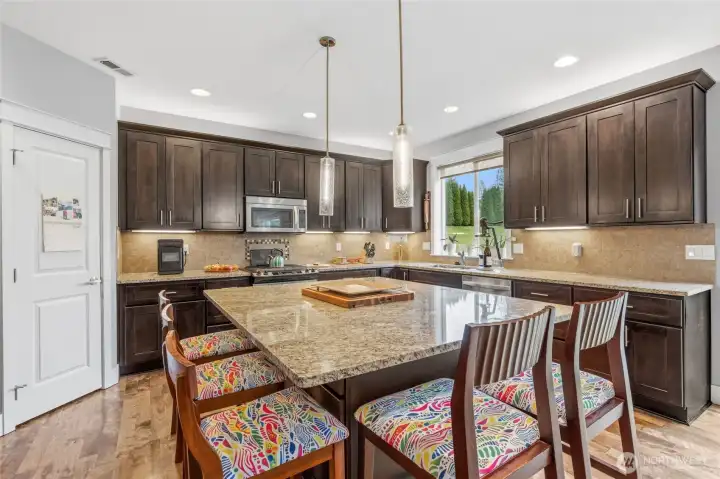 Chef-Inspired Gourmet Kitchen  Custom cabinetry, slab granite counters, stainless Whirlpool appliances, under-cabinet lighting, and exceptional storage create a kitchen both elegant and functional.