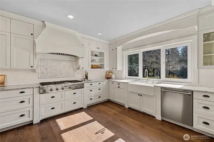 The kitchen is appointed with Thermador appliances: 6-burner gas cooktop, double ovens, warming drawer, dishwasher, refrigerator and beverage fridge.
