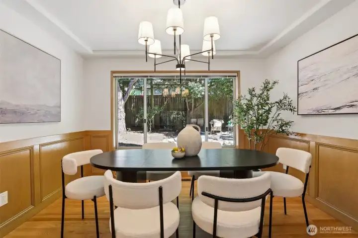Dining room with beautiful wainscotting, designer lighting, and views to private rear yard. Dining room with beautiful wainscotting, designer lighting, and views to private rear yard.