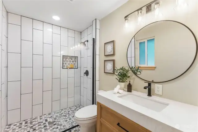 Primary bath is freshly remodeled with ceramic tile and no-curb shower entry, glass panel.