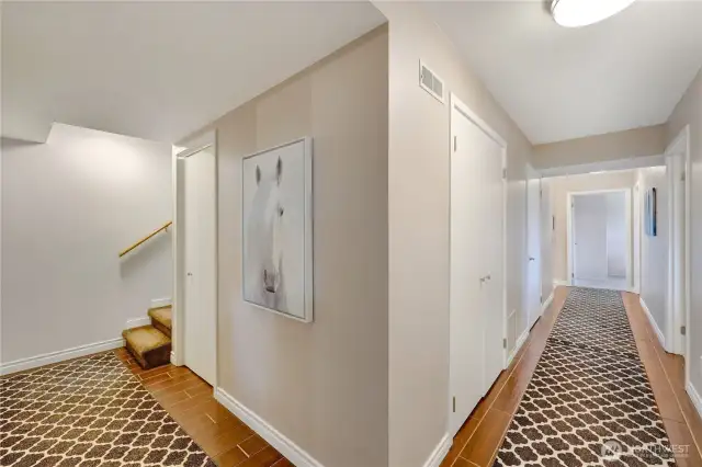 Lower level with three additional bedrooms and large bathroom on the right.  The Theater room and library are on the left side.  That door at the bottom of the stairs leads to a large, lighted storage area.  The mechanincal room is located on the left side of the hallway in front.  The bedrooms are on the right side of the hallway.
