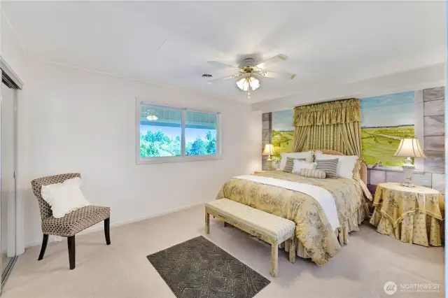 Lower level guest bedroom with custom-painted mural behind the headboard.  That window faces the mountain views and allows natural light into this special space.