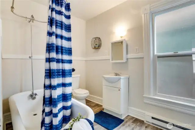 This unit's bathroom boasts fresh new paint, an elegant clawfoot tub, a stylish sink, and a modern medicine cabinet.