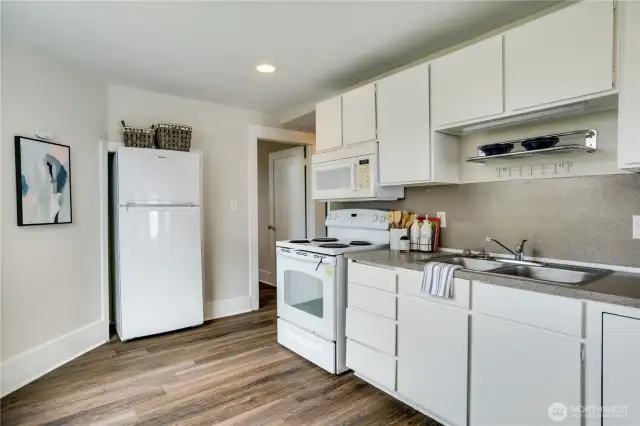 Featuring freshly painted cabinets, a built-in space for the refrigerator, and a convenient double sink, this kitchen combines style and practicality.