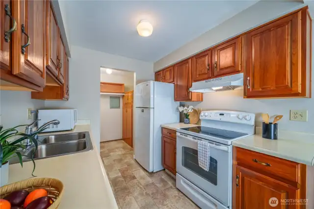 The kitchen includes all white appliances, generous cabinetry, and ample counter space—everything stays!