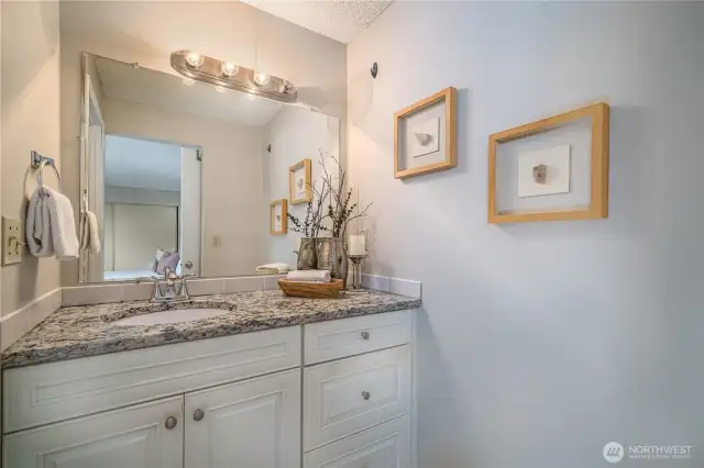 The ensuite bath features granite countertops and upgraded cabinetry for a polished look.