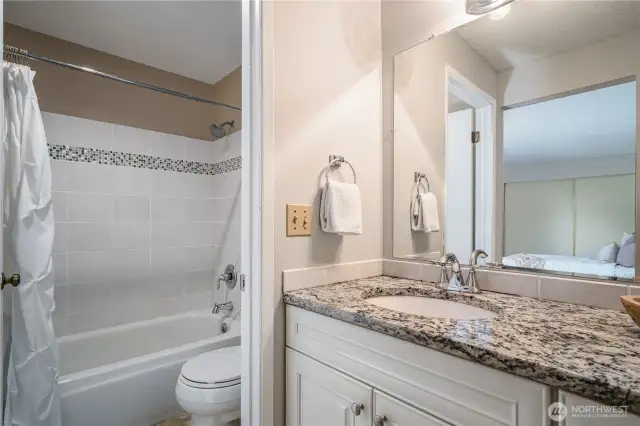 The commode and tiled tub are tucked behind a door for added privacy.