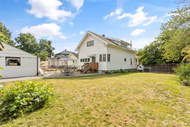 Large, flat backyard surrounded by mature plants with room for more!