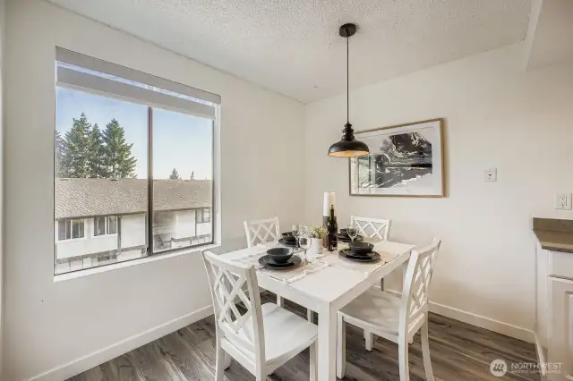 Stylish dining room showcasing new updates and oversized windows that flood the space with natural light.