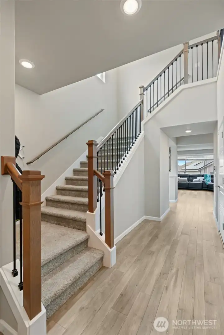 Grand stairway leading upstairs to primary + 3 additional bedrooms and upstairs laundry