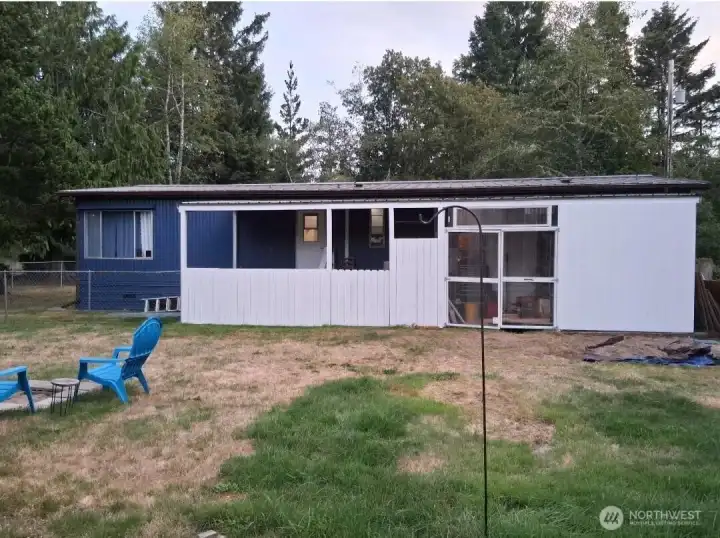 back of house with covered patio and shed