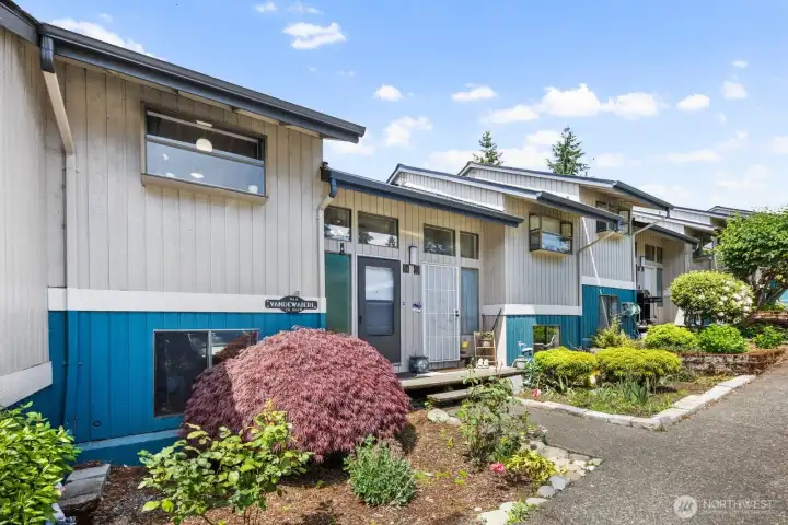 Well-maintained community exterior with mature landscaping, private entrances, and walkable pathways.