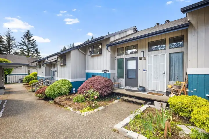 Inviting front exterior with established greenery and a tucked-away residential feel.