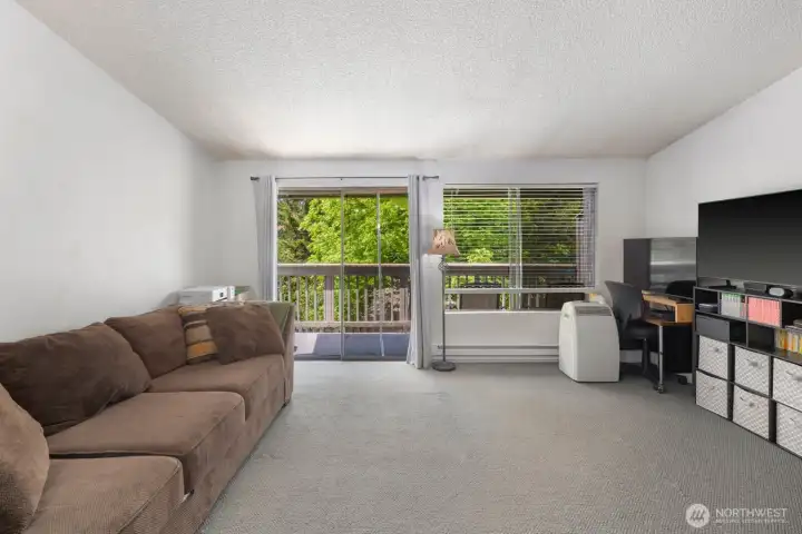 Spacious living area with natural light, flexible layout options, and indoor-outdoor connection through the private deck.