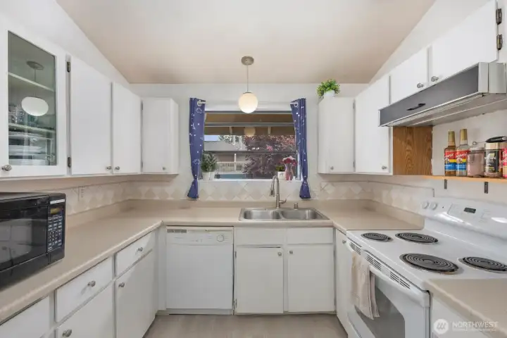 Bright kitchen with generous counter space, ample cabinetry, and a large window bringing in natural light.