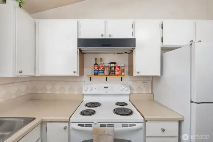 Kitchen with surrounding cabinetry, open counter areas, and easy connection to the dining space.