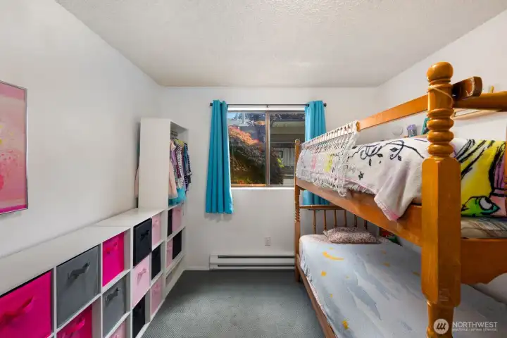 Comfortable bedroom with large window and simple, functional layout.