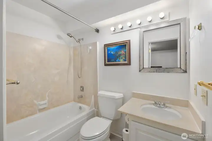 Full bathroom with updated vanity, neutral finishes, and tub/shower combination.