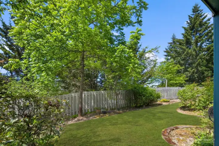 Lush landscaped grounds with winding pathways, mature trees, and open green space.