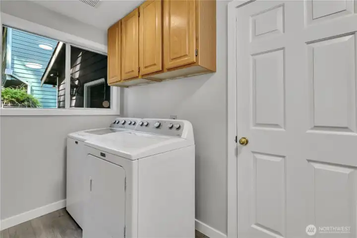 Good sized laundry room with cabinets and closet for more storage