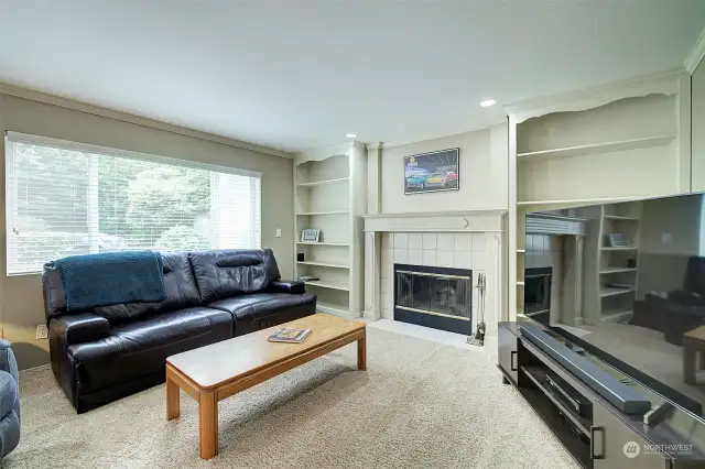 The family room features a fireplace flanked by bookshelves.