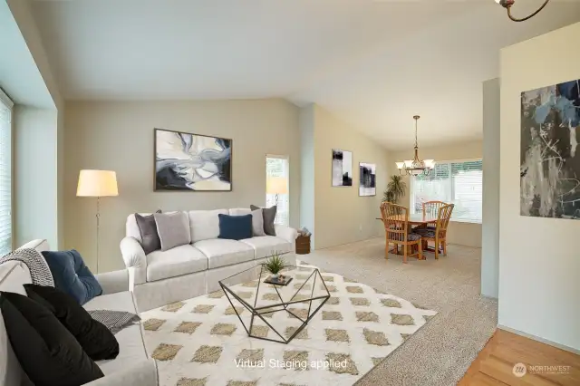 The living room, just off the foyer, features vaulted ceilings and large picture windows.