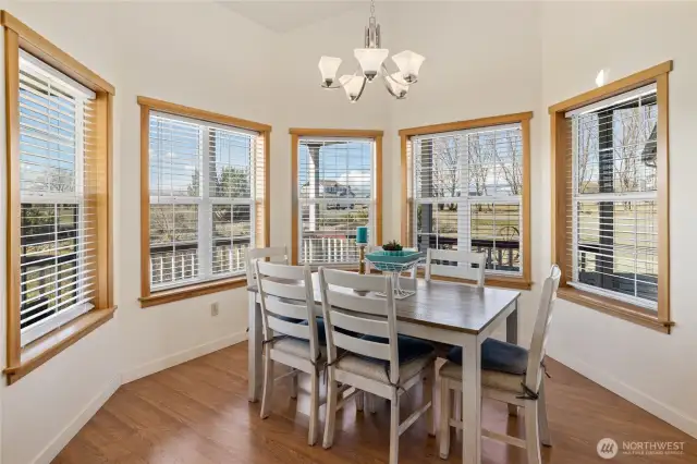 Bay windows frame the dining room table, filling the space with abundant natural light.