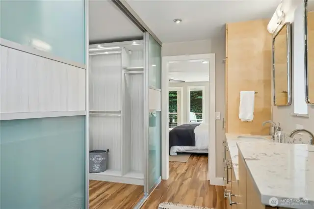 Contemporary primary bath features custom cabinetry and a gorgeous closet.