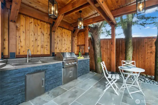 Steps from the hot tub is this fabulous outdoor kitchen. Note all the attention to detail with the use of wood and stone to blend with the surrounding environment.