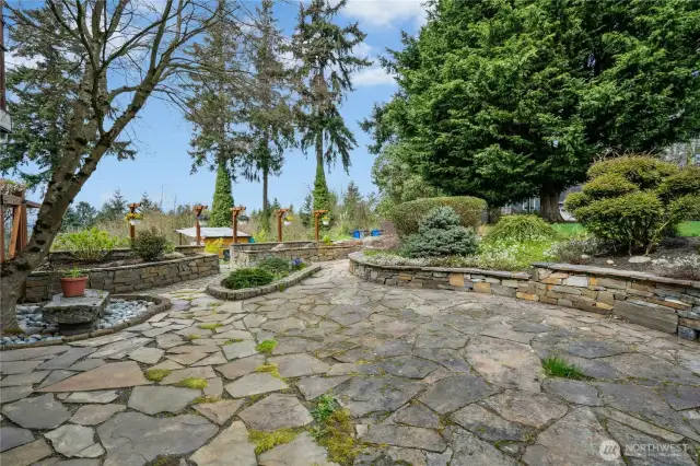 Beautiful natural patio surrounded by lovely trees and shrubbery.