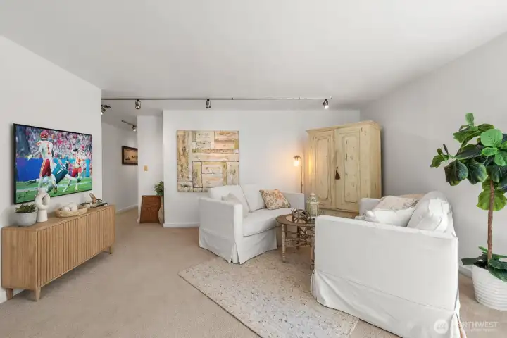 TV virtually staged, great layout for game day. Hardwood floors beneath carpet (buyer to verify)