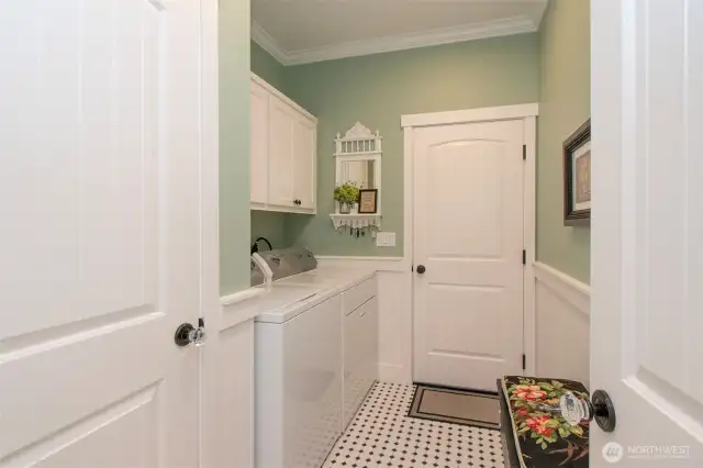 Laundry room has cabinets for storage