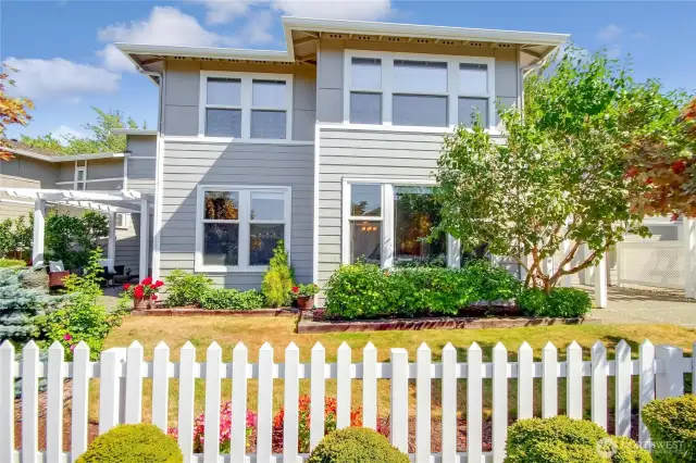 Adorable cottage style main level unit with white picket fence.