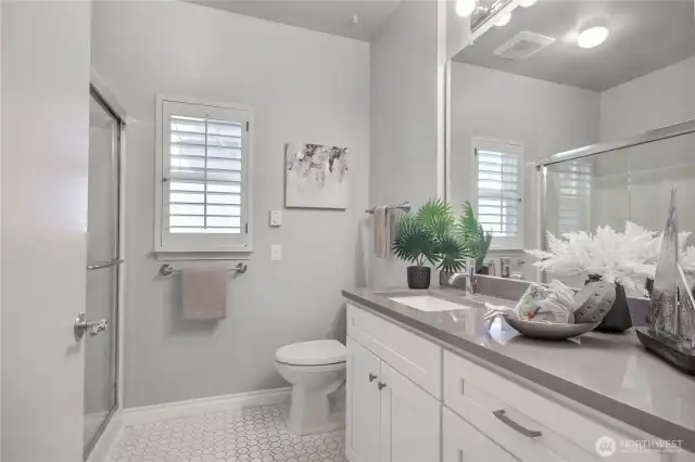 Remodeled 3/4 bathroom with shutter. Tile flooring.