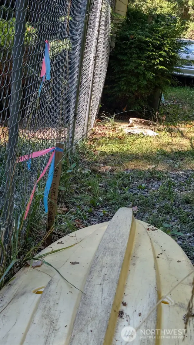 This is the property corner located just off the easement on Dakin. Neighboring fence and shed encroach the property line.