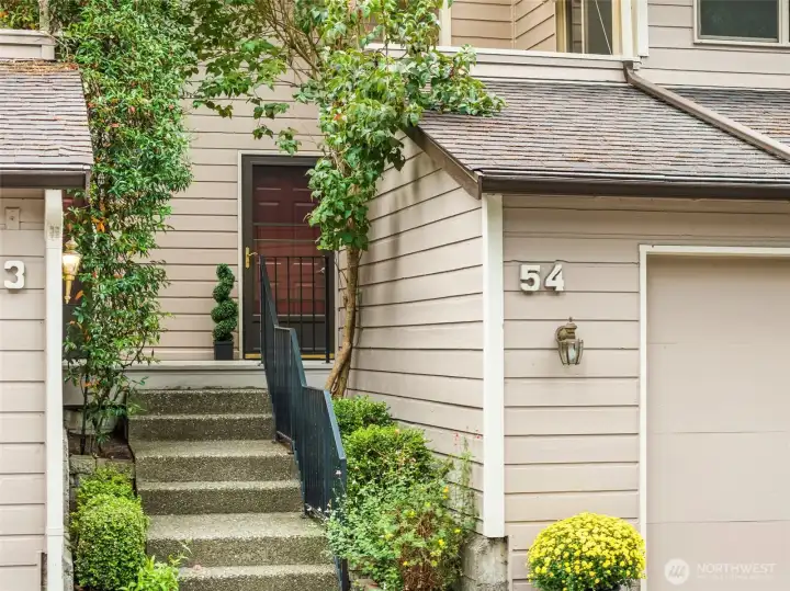 Private entry framed by greenery and landscaped setting.
