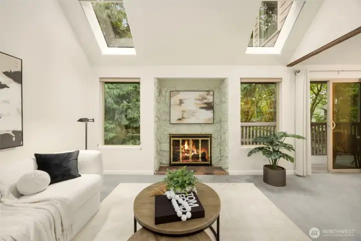 Bright living space with fireplace, treetop views, and seamless flow to the private deck.