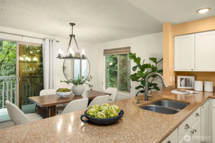 Bright kitchen with double sink, ample counter space, and seamless flow to the dining area and deck.