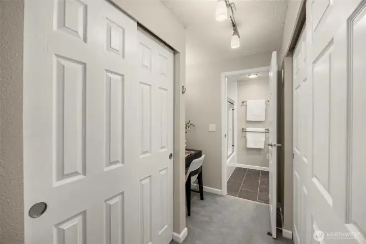 Primary suite walk-through with abundant closet storage and direct connection to updated bathroom.
