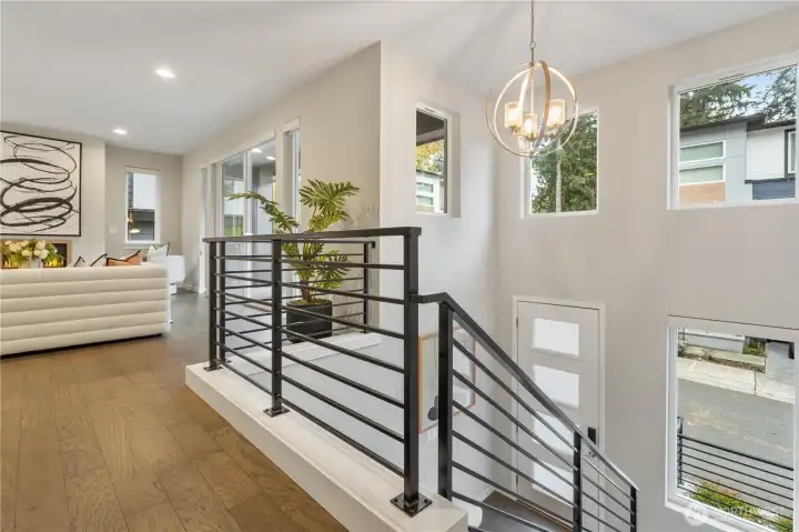 Soaring ceilings, walls of windows, and upscale finishes set the tone with hardwood floors, modern metal railings
