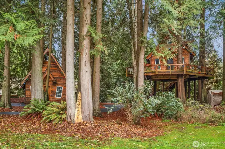 Whimsical playhouse and guest tree house that includes a fireplace and bathroom.